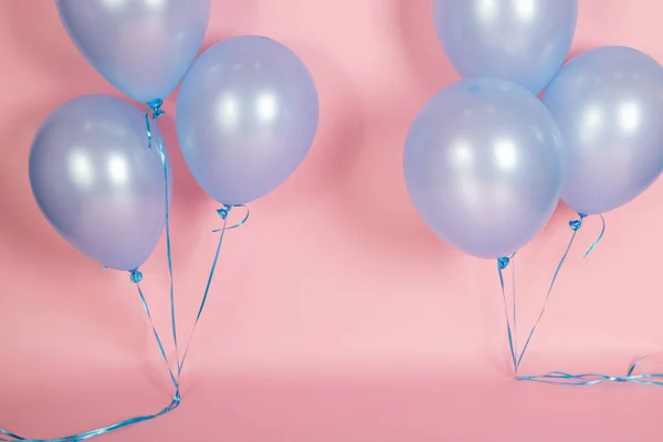 A pink backdrop with blue purple lavender balloons for a backdrop birthday celebration.