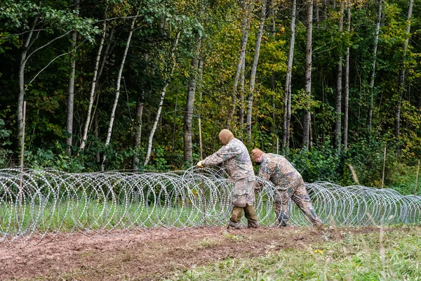 Indra, Letonya - 28 Eylül 2021: Letonya - Letonya Devlet Sınır Muhafızları ve ordusunun dikenli tel örgü kurmaya başladığı Belarus sınırı