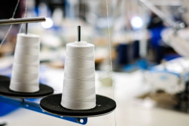 Tekstil fabrikasında endüstriyel dikiş makinesi, iplik, çözülmüş