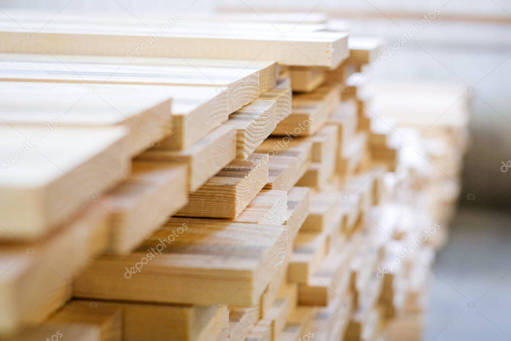 A large pile of wooden boards stored in a sawmill. Selective focus