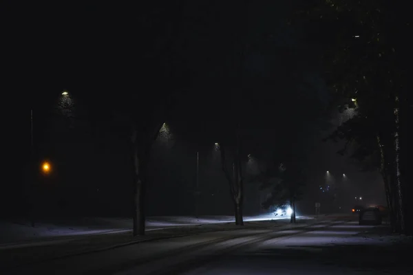 Coches en una tormenta de nieve por la noche en la carretera en invierno. Tráfico en invierno. Desenfocado — Foto de Stock