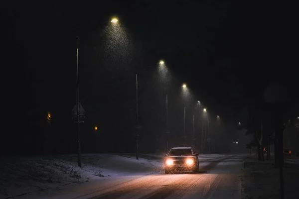 Coches en una tormenta de nieve por la noche en la carretera en invierno. Tráfico en invierno. Desenfocado — Foto de Stock