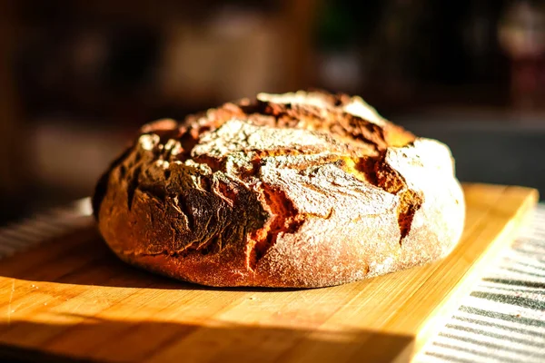 Pão muito fresco de pão de sourdough redondo com uma crosta de ouro. Desfocado — Fotografia de Stock
