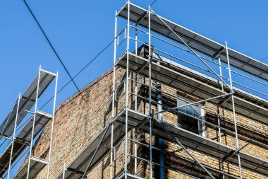 Eski bir tuğla evin yeniden inşası. İnşaat iskelesi, inşaat alanı. Seçici odak