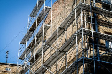 Eski bir tuğla evin yeniden inşası. İnşaat iskelesi, inşaat alanı. Seçici odak