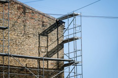 Eski bir tuğla evin yeniden inşası. İnşaat iskelesi, inşaat alanı. Seçici odak