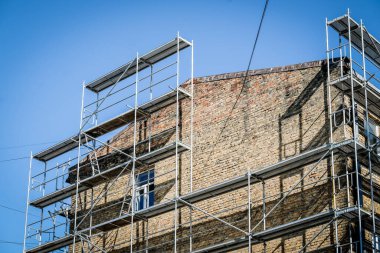 Eski bir tuğla evin yeniden inşası. İnşaat iskelesi, inşaat alanı. Seçici odak