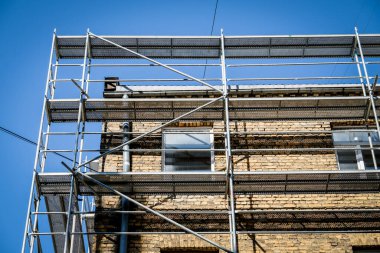 Eski bir tuğla evin yeniden inşası. İnşaat iskelesi, inşaat alanı. Seçici odak