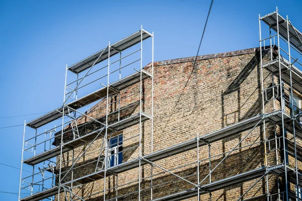 Eski bir tuğla evin yeniden inşası. İnşaat iskelesi, inşaat alanı. Seçici odak