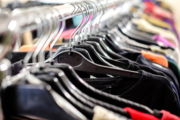 Second hand clothes store. Vintage clothes on the hangers. Defocused