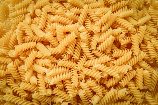 Raw uncooked fusilli pasta, close up background, texture — Foto de Stock