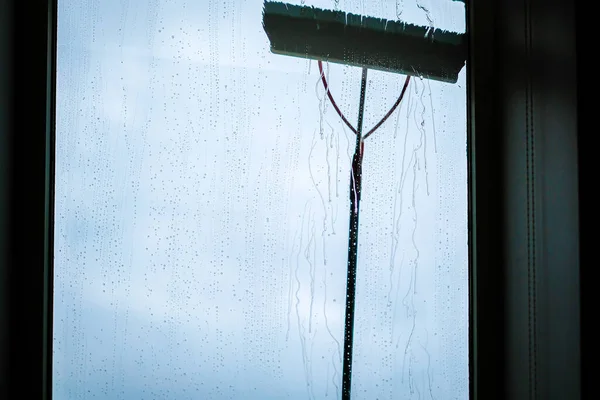 Nettoyage des fenêtres à l'aide d'une brosse télescopique et d'un système de lavage. Nettoyage commercial des fenêtres de l'extérieur avec ciel en arrière-plan. Déconcentrés — Photo