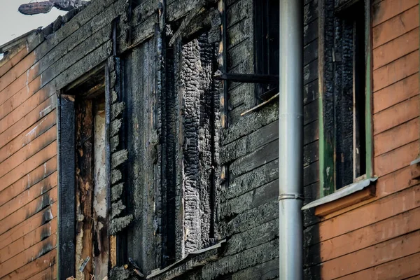 Wooden living house after the fire. The ashes of the house from fire. Burnt destroyed cottage. Selective focus — стоковое фото