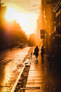 Yağmur, şehirde fırtına var. Su birikintileri, yağmurda insanlar, gün batımı. Dikkati dağılmış. Yüksek kalite fotoğraf