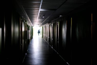 Karanlıkta yalnız yürüyen bir kadın. Karanlık, uzun bir koridorda odaklanmış bir kadın. Yüksek kalite fotoğraf