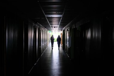 Karanlıkta yalnız yürüyen iki kadın. İki kadın, karanlık, uzun bir koridorda, dikkatleri dağılmış. Yüksek kalite fotoğraf