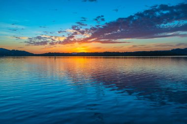 Güneş doğarken yüksek bulutlu su manzarası Orta Sahilde, NSW, Avustralya 'da, Woy Woy' daki Brisbane Suyu 'nu yansıtıyor..