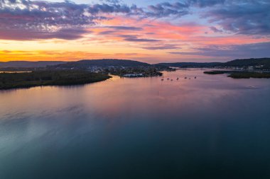 Orta Sahildeki Woy Woy, NSW, Avustralya 'daki Brisbane Suyu' na yansıyan yüksek bulutlu hava gündoğumu manzarası..