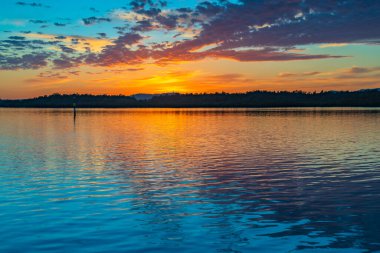 Güneş doğarken yüksek bulutlu su manzarası Orta Sahilde, NSW, Avustralya 'da, Woy Woy' daki Brisbane Suyu 'nu yansıtıyor..