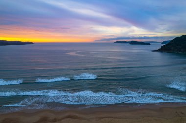 Deniz kıyısında gökyüzü bulutlarla kaplıyken hava gündoğumu Central Coast, NSW, Avustralya 'da Umina Sahili' nde.