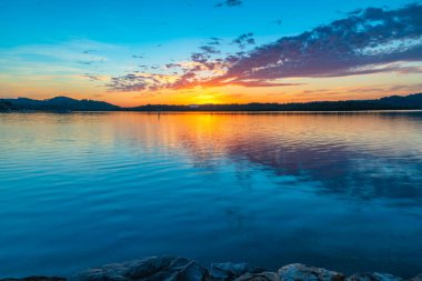 Güneş doğarken yüksek bulutlu su manzarası Orta Sahilde, NSW, Avustralya 'da, Woy Woy' daki Brisbane Suyu 'nu yansıtıyor..