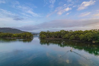 Sabahın erken saatlerinde Woy Woy, NSW, Avustralya 'daki kanalda bulutlar ve yansımalar.