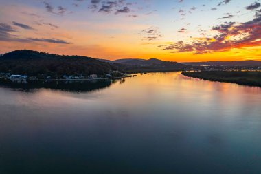Orta Sahildeki Woy Woy, NSW, Avustralya 'daki Brisbane Suyu' na yansıyan yüksek bulutlu hava gündoğumu manzarası..