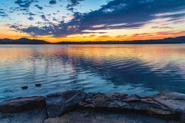 Güneş doğarken yüksek bulutlu su manzarası Orta Sahilde, NSW, Avustralya 'da, Woy Woy' daki Brisbane Suyu 'nu yansıtıyor..