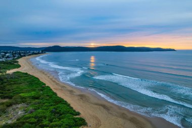 Deniz kıyısında gökyüzü bulutlarla kaplıyken hava gündoğumu Central Coast, NSW, Avustralya 'da Umina Sahili' nde.