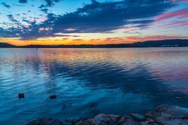 Güneş doğarken yüksek bulutlu su manzarası Orta Sahilde, NSW, Avustralya 'da, Woy Woy' daki Brisbane Suyu 'nu yansıtıyor..