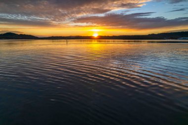Gündoğumu, bulut ve yansımalar Orta Sahildeki Woy Woy rıhtımında, NSW, Avustralya.