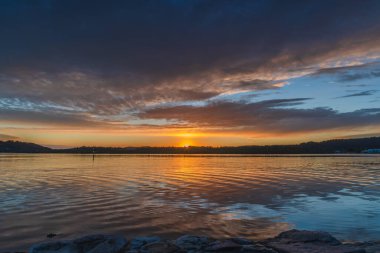 Gündoğumu, bulut ve yansımalar Orta Sahildeki Woy Woy rıhtımında, NSW, Avustralya.