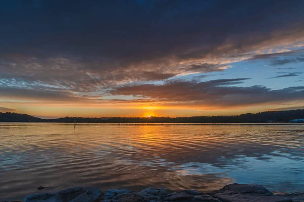 Gündoğumu, bulut ve yansımalar Orta Sahildeki Woy Woy rıhtımında, NSW, Avustralya.