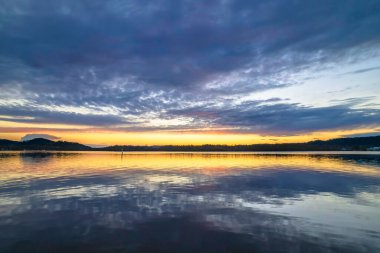 Gündoğumu, bulut ve yansımalar Orta Sahildeki Woy Woy rıhtımında, NSW, Avustralya.