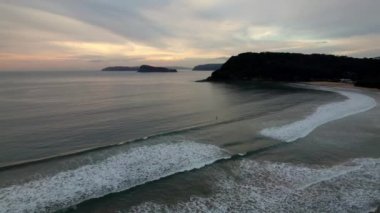 Avustralya, NSW 'nin merkez kıyısındaki Umina Sahili' nde bulutlarla kaplı gündoğumu denizi.