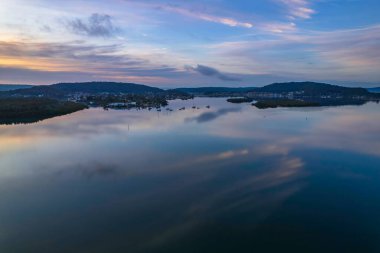 Yağmurdan sonra havadan gün doğumu su manzarası Orta Sahildeki Woy Woy körfezine yansıyan bulutlar, NSW, Avustralya.