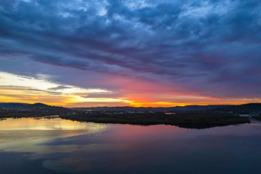 Bulutlar gökyüzünü doldurdu. Gündoğumu su manzarası. Woy Woy 'da Merkez Sahili, NSW, Avustralya..