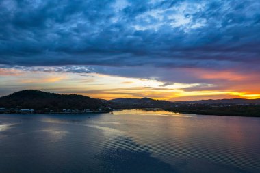 Bulutlar gökyüzünü doldurdu. Gündoğumu su manzarası. Woy Woy 'da Merkez Sahili, NSW, Avustralya..