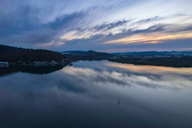 Yağmurdan sonra havadan gün doğumu su manzarası Orta Sahildeki Woy Woy körfezine yansıyan bulutlar, NSW, Avustralya.