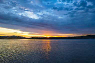 Bulutlar gökyüzünü doldurdu. Gündoğumu su manzarası. Woy Woy 'da Merkez Sahili, NSW, Avustralya..