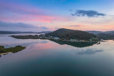Gündoğumu, bulutlar ve yansımalar Orta Sahildeki Woy Woy Rıhtımı 'nda, NSW, Avustralya.