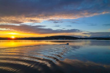 Gündoğumu, bulut ve yansımalar Orta Sahildeki Woy Woy rıhtımında, NSW, Avustralya.