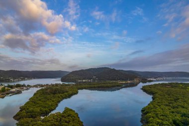 Sabahın erken saatlerinde Woy Woy, NSW, Avustralya 'daki kanalda bulutlar ve yansımalar.