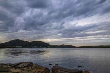 Avustralya, NSW 'nin merkez kıyısındaki Woy Woy' da güneşin doğuşu için bulutlu bir gökyüzü..