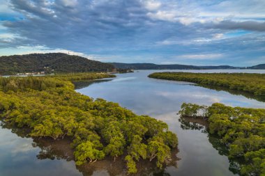 Sabahın erken saatlerinde Woy Woy, NSW, Avustralya 'daki kanalda bulutlar ve yansımalar.