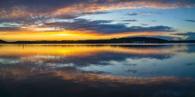 Gündoğumu, bulut ve yansımalar Orta Sahildeki Woy Woy rıhtımında, NSW, Avustralya.