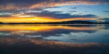 Gündoğumu, bulut ve yansımalar Orta Sahildeki Woy Woy rıhtımında, NSW, Avustralya.