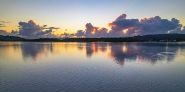 Bulutlar ve yansımalarla birlikte gündoğumu suları Central Coast, NSW, Avustralya 'daki Woy Woy rıhtımında..