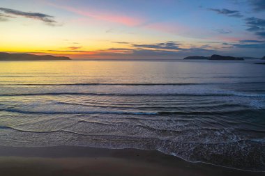 Deniz kenarında gün doğumu bulutlar ve Umina Sahili 'nde yumuşak deniz Central Coast, NSW, Avustralya.
