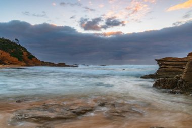 Avustralya, NSW 'nin güney kıyısındaki Eurobadalla Shire' de Bermagui 'de bulutlu ve dalgalı gün doğumu deniz manzarası..